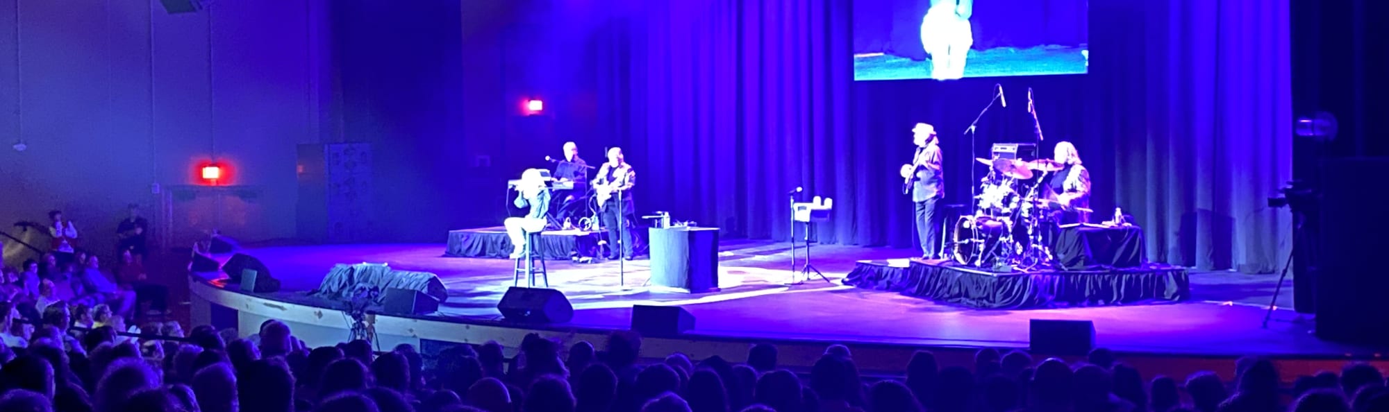 signer on stage in chair washed out by the lights State College